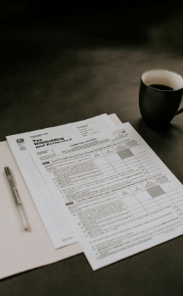 black ceramic mug beside white printer paper